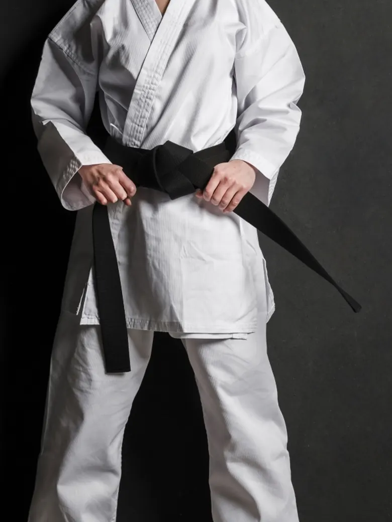 Karateka în kimono alb cu centură neagră