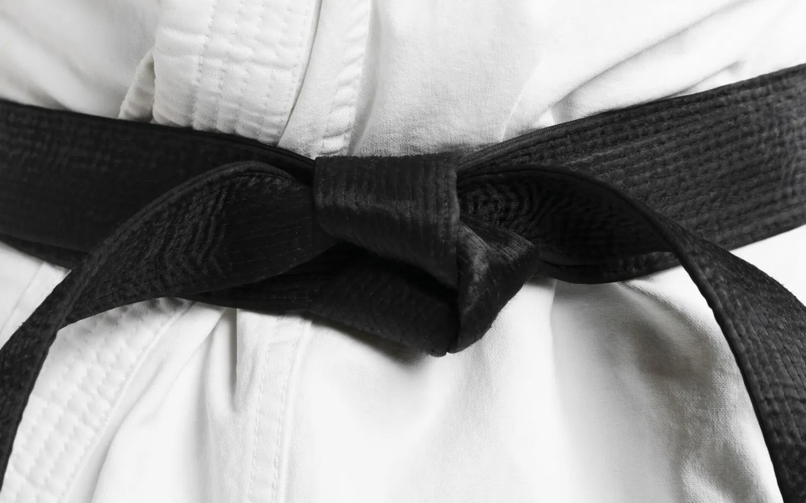Centură neagră legată peste un kimono alb de arte marțiale